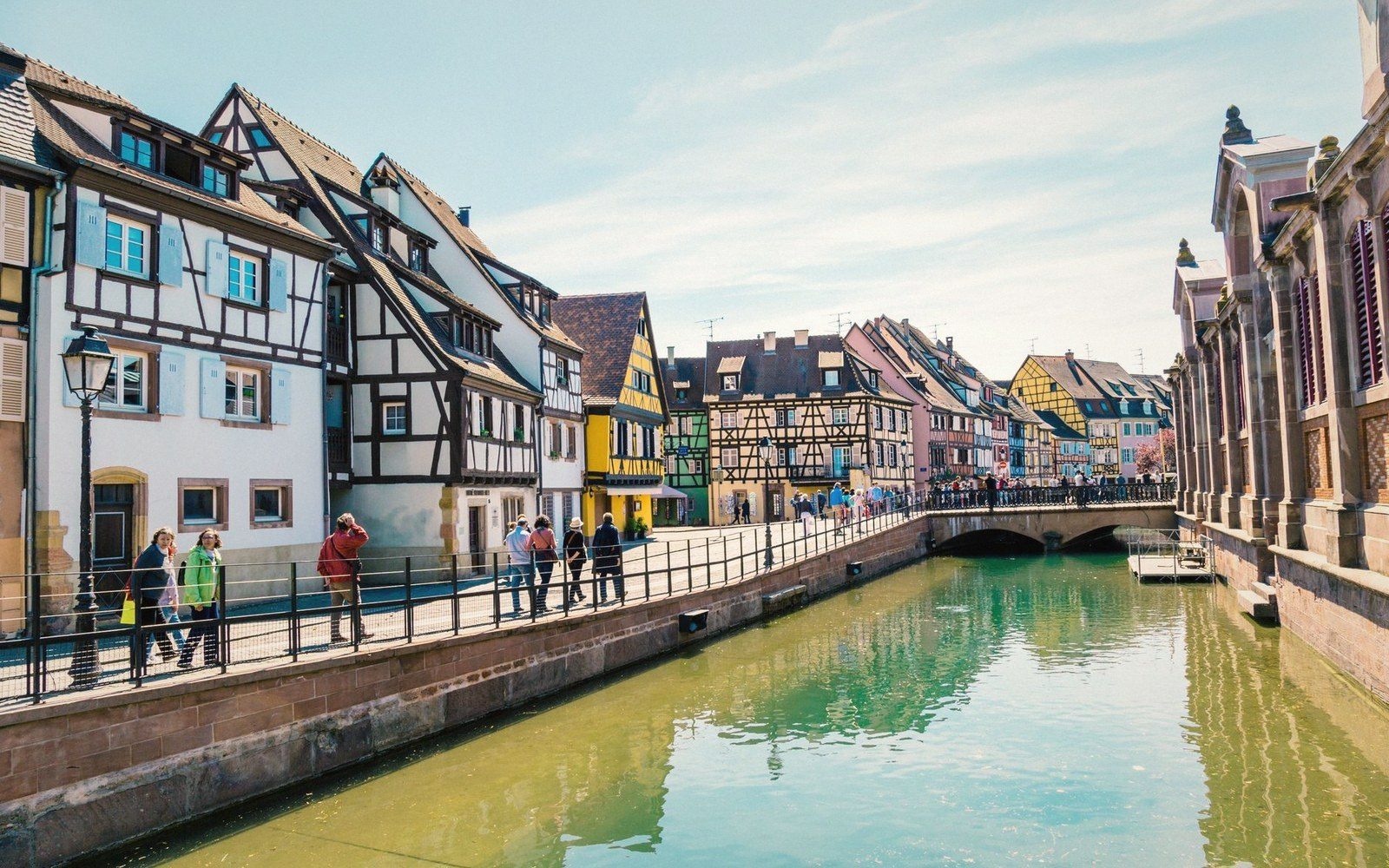 A canal-side street in Colmar's old town, half-timbered facades, mid-morning light, no tourists in foreground