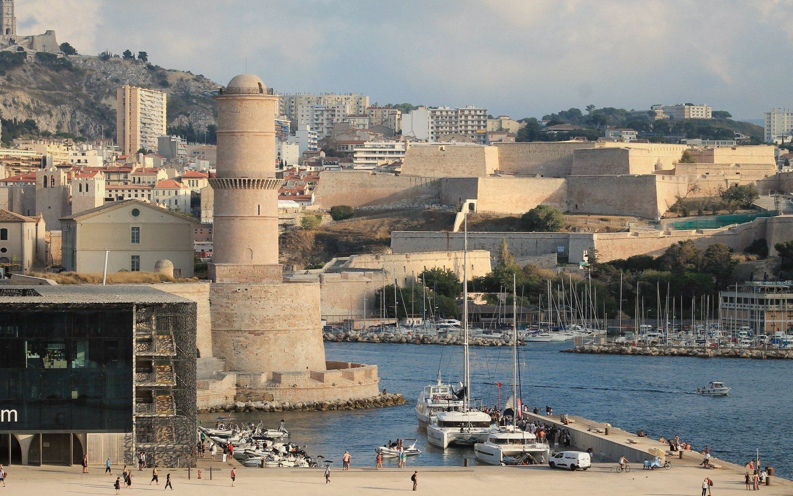 Fort Saint-Jean's round tower overlooks Marseille's harbor with yachts moored below