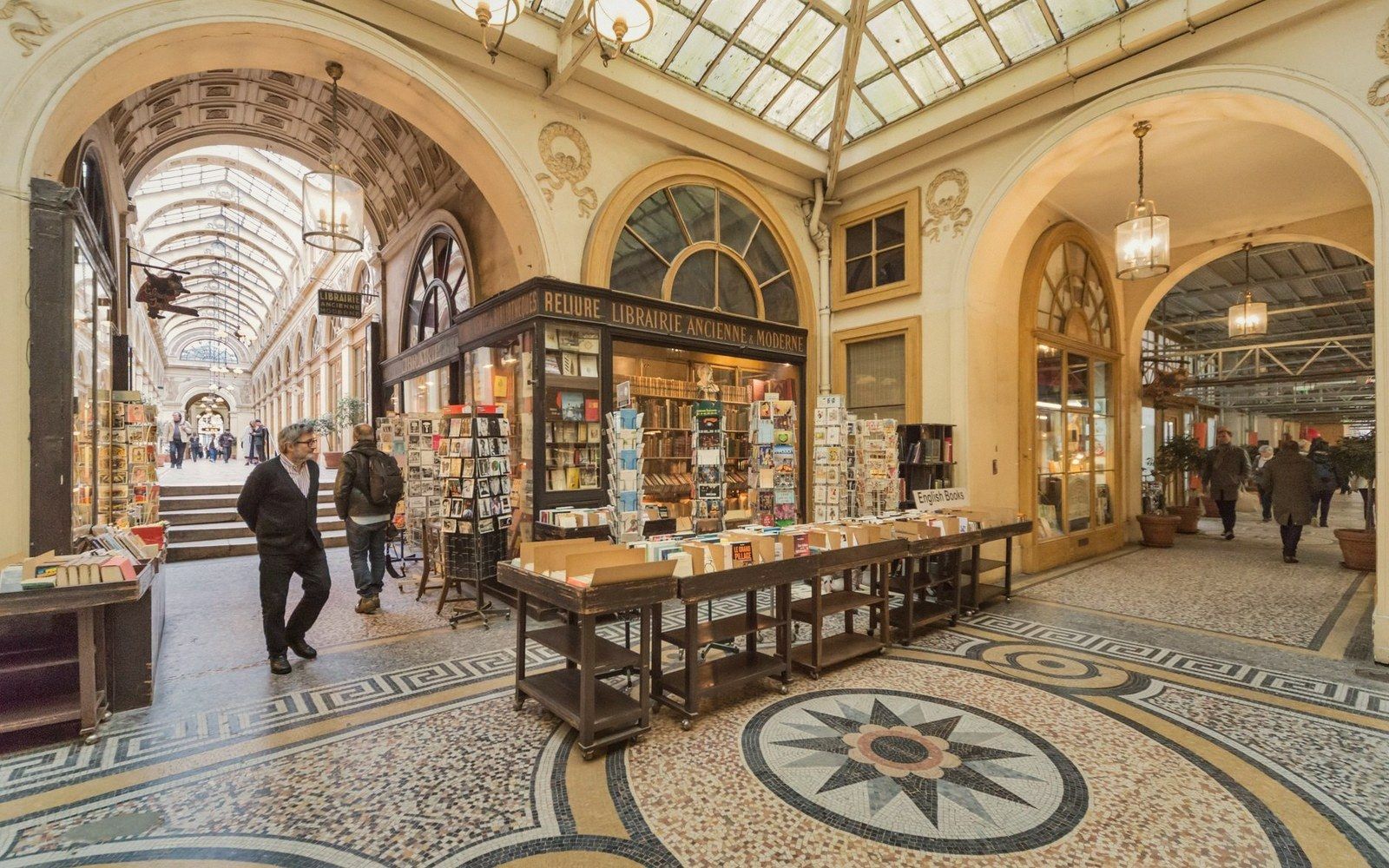 Vaulted glass-roofed arcade with an antiquarian bookshop and mosaic tiled floor